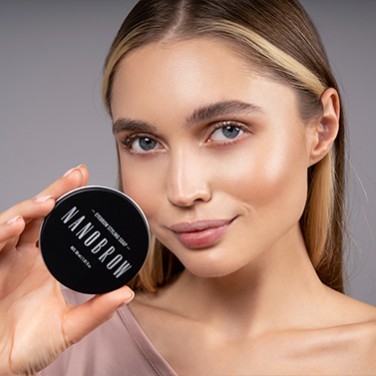 Une femme aux yeux bleus tenant le savon coiffant devant son visage