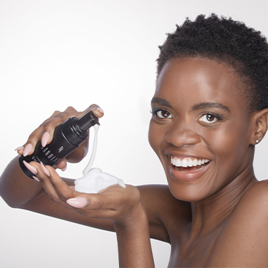 Une femme noire appliquant de la mousse de shampoing sur sa main